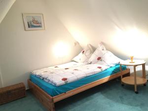 ノルトシュトラントにあるReetdachhaus Deichkroneのベッドルーム1室(ベッド1台、ランプ付きテーブル付)