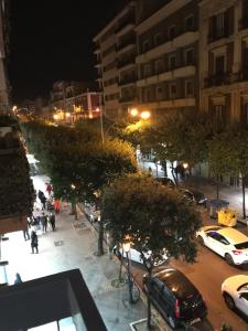 Una calle de la ciudad por la noche con coches aparcados en 70's Luxury Cavour, en Bari