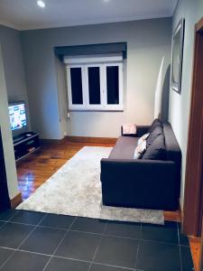 a living room with a couch and a television at Belem Aloja in Lisbon