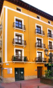 un edificio amarillo con balcones en un lateral en Laila Home, en Barbastro