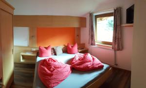 Schlafzimmer mit einem Bett mit rosa Bettwäsche und einem Fenster in der Unterkunft Haus Falke in Sölden