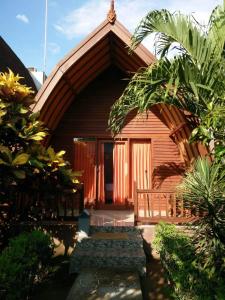 una casa de madera con un arco delante de ella en Kelapa Gading Bungalows, en Gili Air