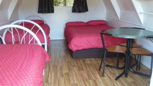 een kleine kamer met een bed en een tafel en stoelen bij Westport Kiwi Holiday Park & Motels in Westport