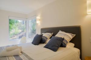 a bedroom with a bed with pillows and a window at The Villa Dunsborough in Dunsborough