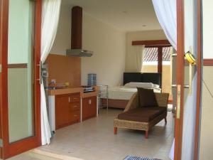 Habitación con 1 dormitorio con 1 cama y 1 silla en Fruits Villa en Sanur