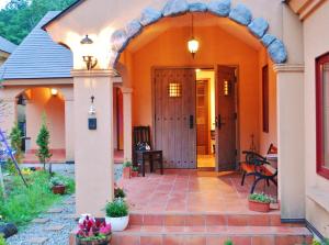 una entrada a una casa con un arco en Aromatic Garden Villa La Poltrona en Nasu