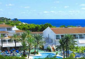 a view of a resort with a pool and palm trees at FERGUS Club Font de Sa Cala Beach in Capdepera