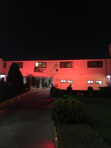 un edificio se ilumina de rojo por la noche en Hotel Puerta del Sol en Toluca