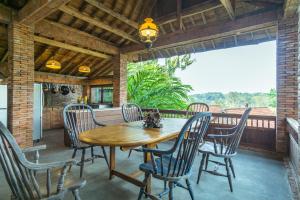 a porch with a wooden table and chairs on a balcony at Harum Manis Cottages in Jepara