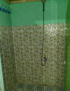 baño con ducha y puerta de cristal en Crystall Guesthouse en Banda Aceh