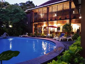 a swimming pool in front of a house at Sanur Agung Hotel in Sanur