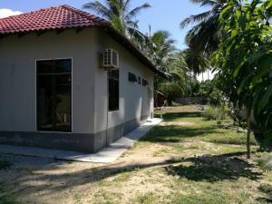 a small white house with a yard at Relaxs Homestay in Kota Bharu