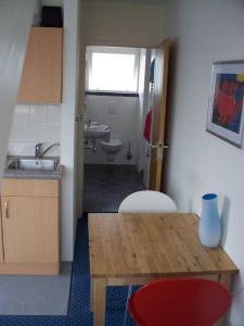 una pequeña cocina con mesa y fregadero en Appartementen Bergen aan Zee de Schelp, en Bergen aan Zee