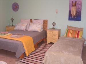 a bedroom with two beds and a dresser and a bedskirts at Marianna Holiday Home in Nafplio