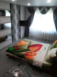 イヴァノヴォにあるApartment on Pervaya Polevayaのベッドルーム1室(花の飾られたベッド1台付)