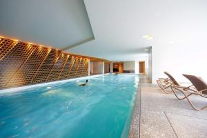 a pool in a building with a person in the water at Bellevue Parkhotel & Spa - Relais & Châteaux in Adelboden