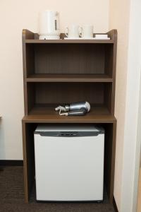 a shelf with a white refrigerator in a room at Laon Inn Gion Nawate in Kyoto