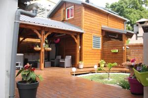 a house with a wooden deck with a patio at Kaz Passion in Sainte-Marie