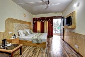 a bedroom with a bed and a tv and a couch at Hotel Highway inn in Manāli