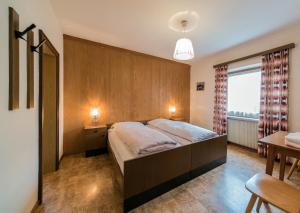 a bedroom with a large bed and a window at Residence Trametsch in Bressanone +4 photos