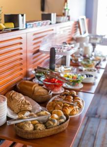 una línea de buffet con varios tipos de pan y repostería en Grand Jules - Boat Hotel, en Budapest