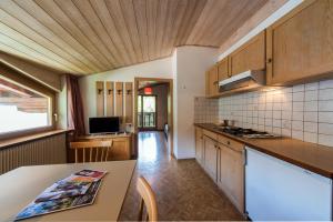 eine Küche mit Holzschränken und einem Tisch mit einer Arbeitsplatte in der Unterkunft Residence Trametsch in Brixen