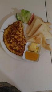 un plato de comida con un sándwich y queso y patatas fritas en Warung Santa Fe and Bungalows, en Amed
