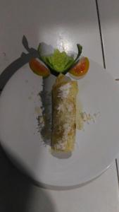 un plato blanco con un trozo de pastel y verduras en Warung Santa Fe and Bungalows, en Amed