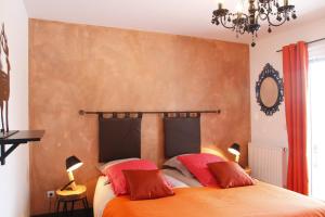 a bedroom with a bed with two red pillows at Chambres d'hôtes Souffle Nature in Montenois