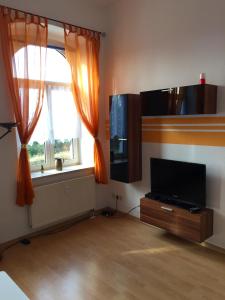 a living room with a flat screen tv and a window at Ferienwohnungen Plauen in Plauen