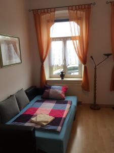 a bed sitting in a room with a window at Ferienwohnungen Plauen in Plauen