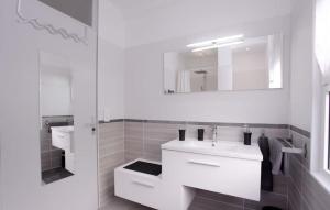 ein weißes Badezimmer mit einem Waschbecken und einem Spiegel in der Unterkunft Place to beach - Terrasse Bord de mer Croisette in Cannes