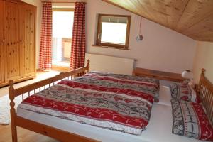 a bedroom with a bed with a red comforter at Apartment Sagtaler Spitze in Alpbach