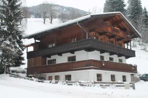 a large wooden building in the snow with trees at Apartment Sagtaler Spitze in Alpbach