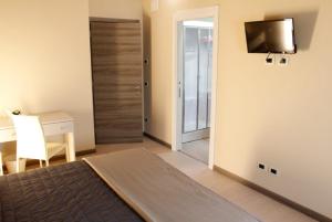 - une chambre avec un lit, un bureau et une télévision dans l'établissement Agriturismo Zapparè Farm Hotel, à Trevignano