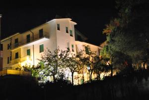 a large white building at night with lights at Pensione Andrea in Chianciano Terme