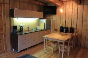 a kitchen with a table and a refrigerator and a counter at Vanasauna Guesthouse in Valma
