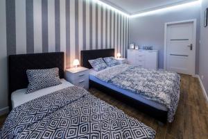 1 dormitorio con 2 camas y pared a rayas en Apartament Żeglarska Loft U4, en Giżycko