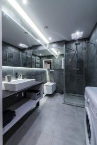 y baño con lavabo, ducha y lavadora. en Apartament Żeglarska Loft U4, en Giżycko