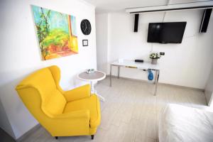 a living room with a yellow chair and a tv at Blue Sky in Ashkelon in Ashkelon