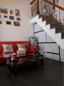 a living room with a red couch and a staircase at Good Mood Cottage in Hengchun South Gate
