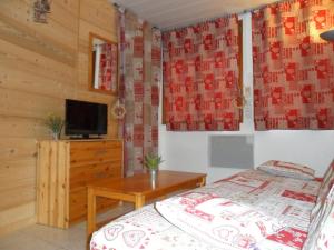 um quarto com uma cama, uma televisão e uma mesa em 2 Pièces+Terrasse CHAMONIX CENTRE em Chamonix-Mont-Blanc
