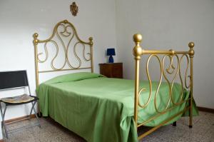 a bedroom with a bed with a green comforter at Silvio in Massa Marittima