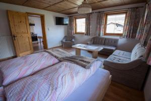 sypialnia z dużym łóżkiem i kanapą w obiekcie Landhaus KATRIN w mieście Holzgau
