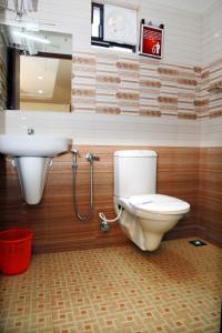 a bathroom with a toilet and a sink at Anandkrishna Residency in Guruvāyūr