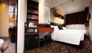 Habitación de hotel con cama y baño en Lander Hotel Prince Edward, en Hong Kong