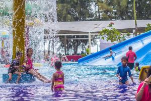 um grupo de crianças brincando em um parque aquático em Qastury Gold Coast Morib Resort em Morib