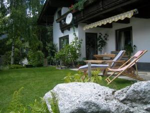 eine Terrasse mit Stühlen und einem Tisch im Hof in der Unterkunft Ferienwohnung Holzer Maria in Mittersill