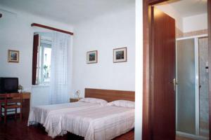 a bedroom with a bed and a room with a television at Pensione Rittmeyer in Trieste