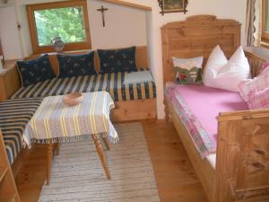 a bedroom with a bed and a couch and a table at Ferienwohnung Holzer Maria in Mittersill